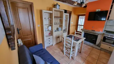 a living room with a blue couch and a table at Casa jardin Mariana in Lubián