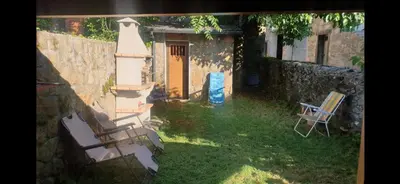 a yard with two chairs and a yellow door at Casa jardin Mariana in Lubián
