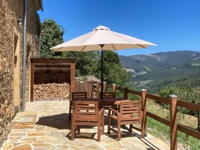 a table and chairs under an umbrella on a patio at Casa Liñeiras in Lugo