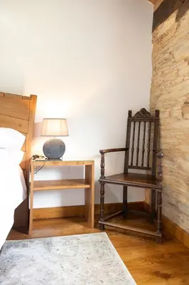 a bedroom with a chair and a table with a lamp at Casa Liñeiras in Lugo