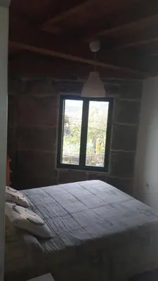 a bedroom with a large bed and a window at Casa Amil da Vilaboa, Allariz in Allariz