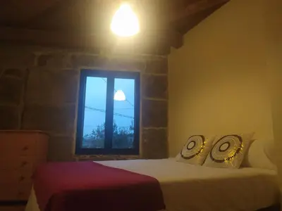 a bedroom with a bed and a window at Casa Amil da Vilaboa, Allariz in Allariz