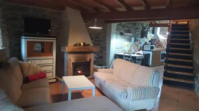 a living room with a couch and a fireplace at Casa Amil da Vilaboa, Allariz in Allariz