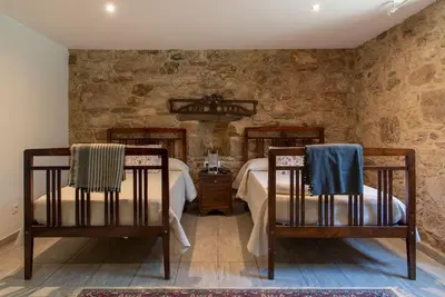 a bedroom with two beds and two chairs at CASA DO LEAL SILVER WAY in Silleda