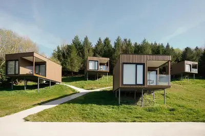 a group of modular houses on a grass field at Cabañas Alcobas do Sil Ecoturismo in Parada del Sil