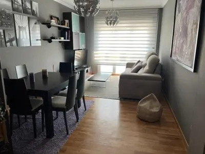 a blue room with two beds and a window at San Roque Apartamento in Ribadeo