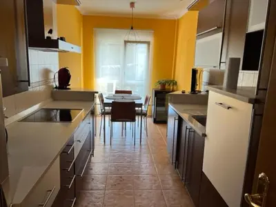 a kitchen with yellow walls and a table in it at San Roque Apartamento in Ribadeo