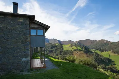 a stone house with a view of the mountains at El Vallín de Alba in La Artosa