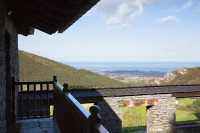 a balcony of a house with a view of the ocean at El Vallín de Alba in La Artosa