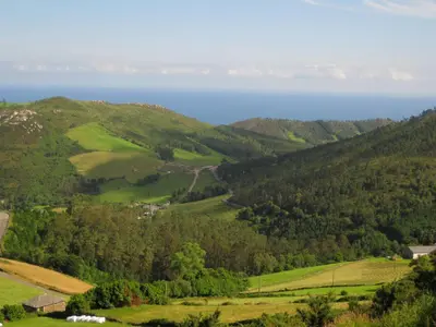 a view of the hills with the ocean in the background at El Vallín de Alba in La Artosa