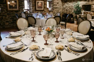a table with plates and wine glasses on it at Pazo de Bendoiro in Bendoiro