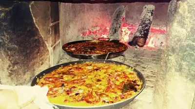 two pans of food are cooking in an oven at Pazo de Bendoiro in Bendoiro