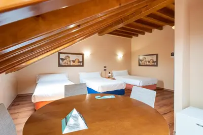 a room with two beds and a table with chairs at Hotel Alda Lalín in Lalín