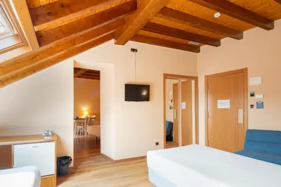 a bedroom with a bed and a tv on the wall at Hotel Alda Lalín in Lalín