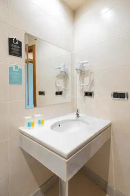 a bathroom with a sink and a mirror at Hotel Alda Lalín in Lalín