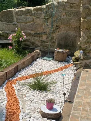 a garden with rocks and a stone wall at Carballo Alenza,2 in Castro Caldelas
