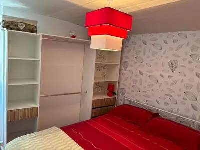a small bedroom with a red bed and shelves at Carballo Alenza,2 in Castro Caldelas