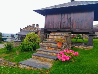 a set of stairs in front of a house with flowers at Pajar in Braña