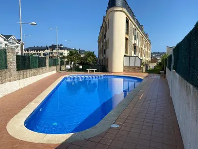 a blue swimming pool in front of a building at Barreiros Playa Altar in Barreiros