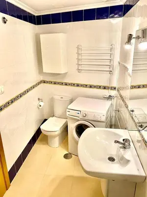 a bathroom with a toilet sink and a washing machine at Barreiros Playa Altar in Barreiros