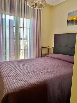 a bedroom with a bed and a large window at Barreiros Playa Altar in Barreiros