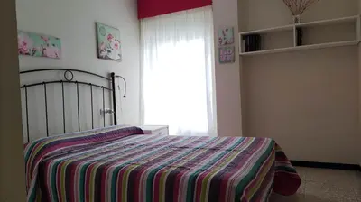 a bedroom with a bed with a striped blanket and a window at Amplio piso en Pontedeume in Puentedeume