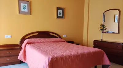 a bedroom with a bed and a dresser and a mirror at Amplio piso en Pontedeume in Puentedeume