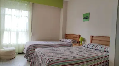 a bedroom with two beds and a window at Amplio piso en Pontedeume in Puentedeume