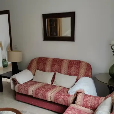 a couch sitting in a living room with a mirror at Casa Xarreiro in Chantada