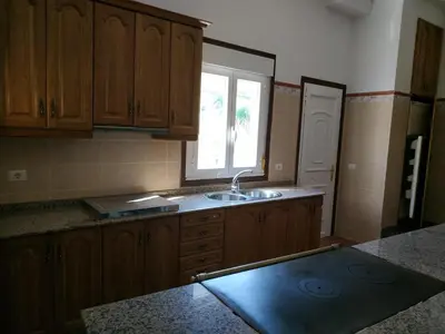 a kitchen with wooden cabinets and a sink and a window at Casa Xarreiro in Chantada