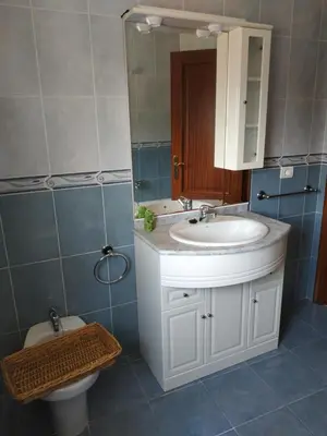 a bathroom with a sink and a toilet and a mirror at Casa Xarreiro in Chantada