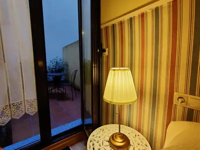 a lamp sitting on a table next to a glass door at Alojamiento Real Monforte de Lemos in Monforte de Lemos