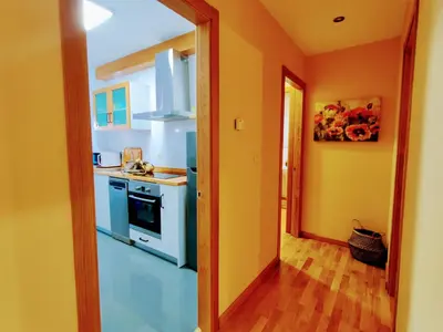 a kitchen with orange walls and a white stove top oven at Alojamiento Real Monforte de Lemos in Monforte de Lemos