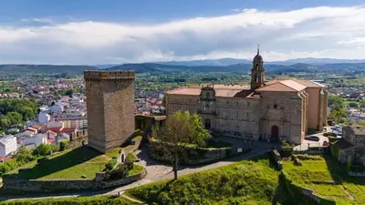 an old building with a clock tower in a city at Alojamiento Real Monforte de Lemos in Monforte de Lemos