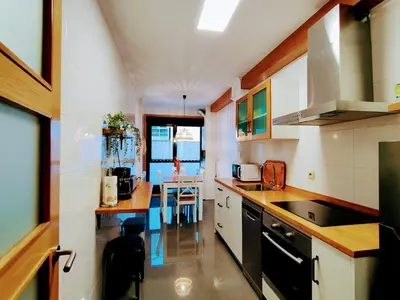 a kitchen with white cabinets and a table in it at Alojamiento Real Monforte de Lemos in Monforte de Lemos