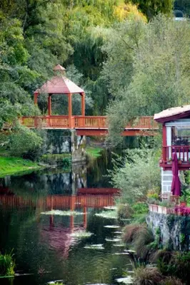 a bridge over a pond with a gazebo in a garden at Casa MENDEZ - ALLARIZ in Ourense