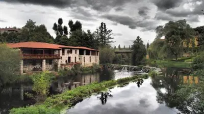 a river with buildings next to a river with trees at Casa MENDEZ - ALLARIZ in Ourense