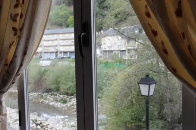 a window with a street light and a view of a river at Hostal Burbia in Villafranca del Bierzo