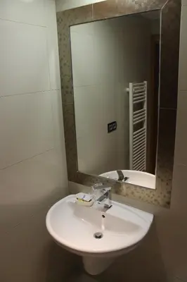 a bathroom with a white sink and a mirror at Hostal Burbia in Villafranca del Bierzo