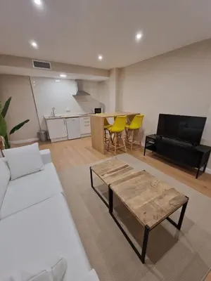 a living room with a couch and a table at Apartamentos Turísticos MENCÍA in Monforte de Lemos