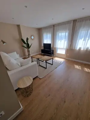 a living room with a white couch and a table at Apartamentos Turísticos MENCÍA in Monforte de Lemos