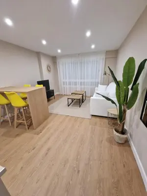 a living room with a table and a couch at Apartamentos Turísticos MENCÍA in Monforte de Lemos