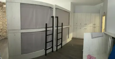 a room with a wall of stalls in a building at Albergue a Carballeira in Villalba