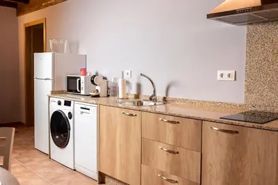 a kitchen with a sink and a washing machine at Pallozas Turísticas Ridicodias - A Vieira in Laza