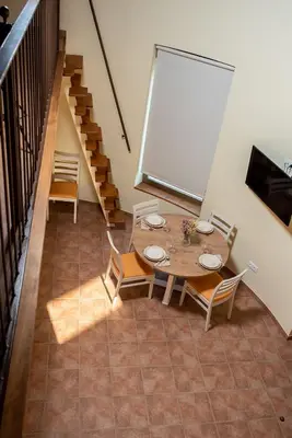 a dining room with a table and chairs and stairs at Pallozas Turísticas Ridicodias - A Vieira in Laza