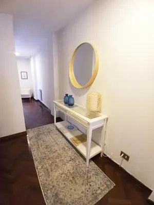 a white dressing table with a mirror and a rug at Sobre la Ría in Viveiro