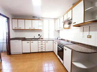 a kitchen with white cabinets and marble counter tops at Sobre la Ría in Viveiro