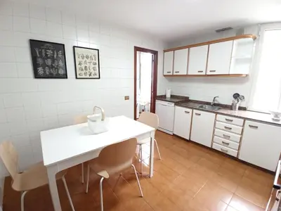 a kitchen with a white table and chairs at Sobre la Ría in Viveiro