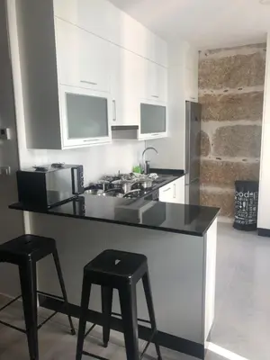 a kitchen with a counter and two stools in it at A esmorga in Ourense