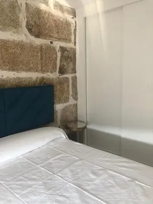 a bedroom with a brick wall and a bed at A esmorga in Ourense
